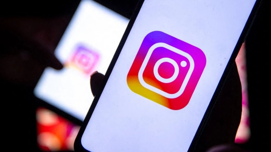 A close-up shot of a smartphone screen displaying the brightly colored Instagram logo emblem.