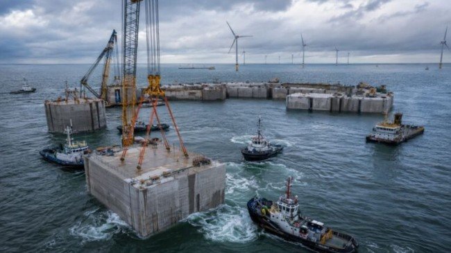 Offshore construction vessels working in the North Sea installing massive concrete caissons for Belgium's artificial energy island
