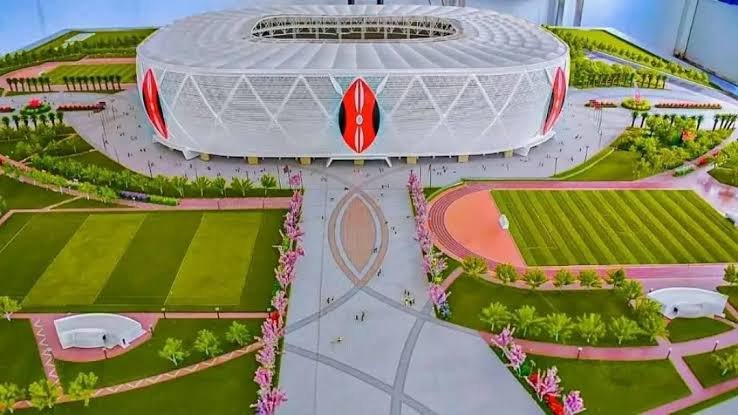 A wide-angle shot of the construction site at Talanta Sports City Stadium in Nairobi showing the tiered seating structures and heavy machinery.