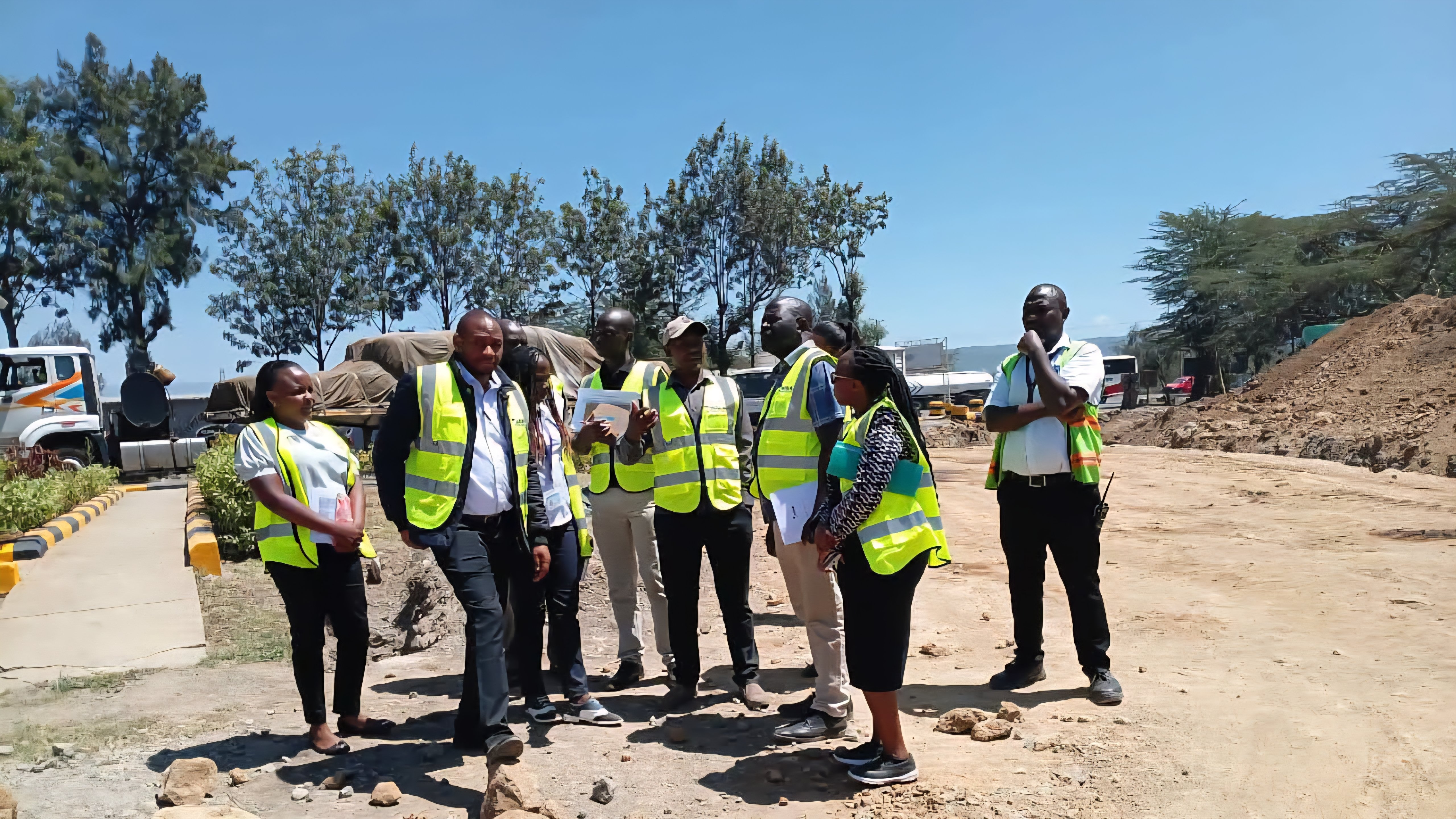 A heavy commercial truck parked at the Gilgil Weighbridge Station with technical staff visible near the weighing scales and control office.