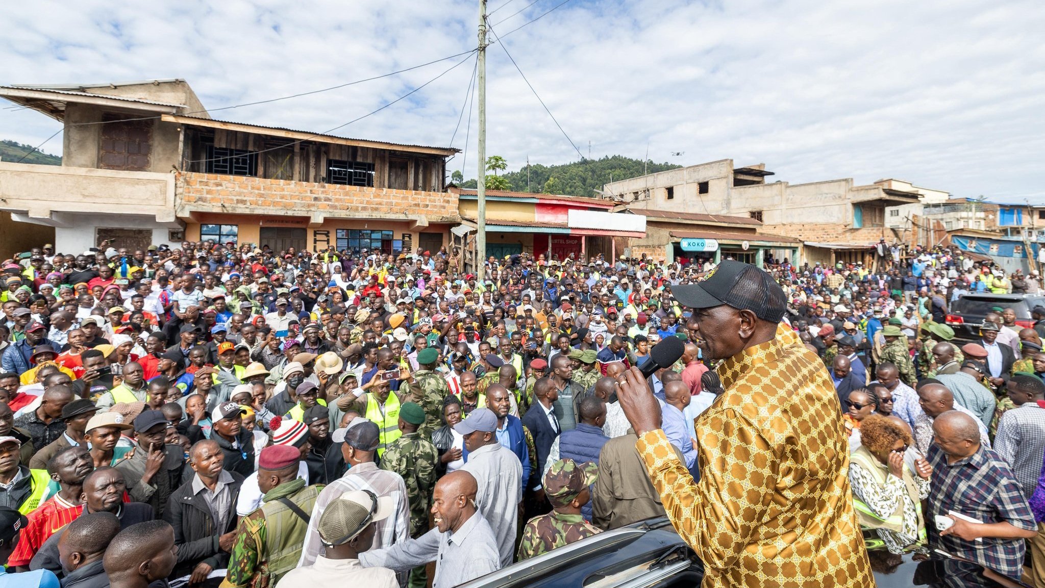 President William Ruto addressing a large crowd from the sunroof of a vehicle during a tour of infrastructure project sites in Nyamira.