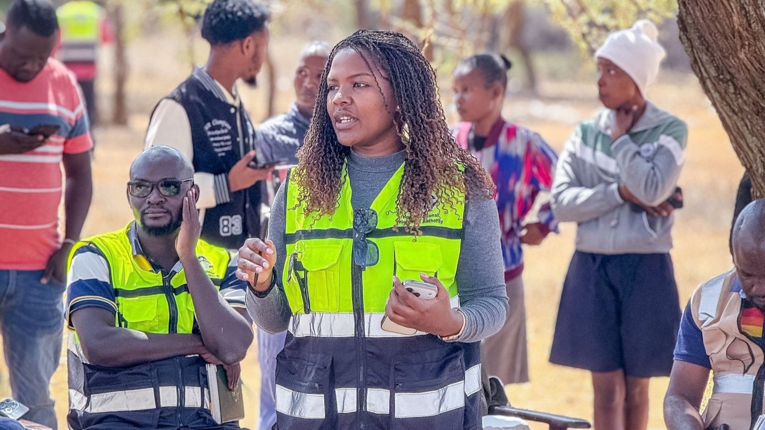 A Kenya National Highways Authority representative speaking to community members during an Environmental and Social Impact Assessment public participation meeting under a tree in Samburu County.