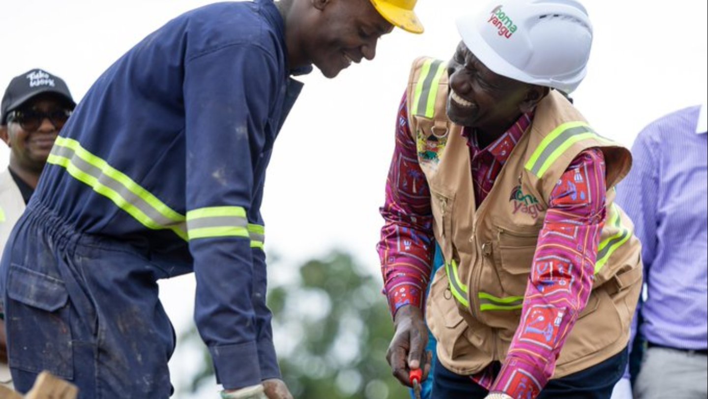 President William Ruto wearing a white hard hat and reflective safety vest at a construction site in Yala, Siaya County, during the foundation stone laying ceremony.