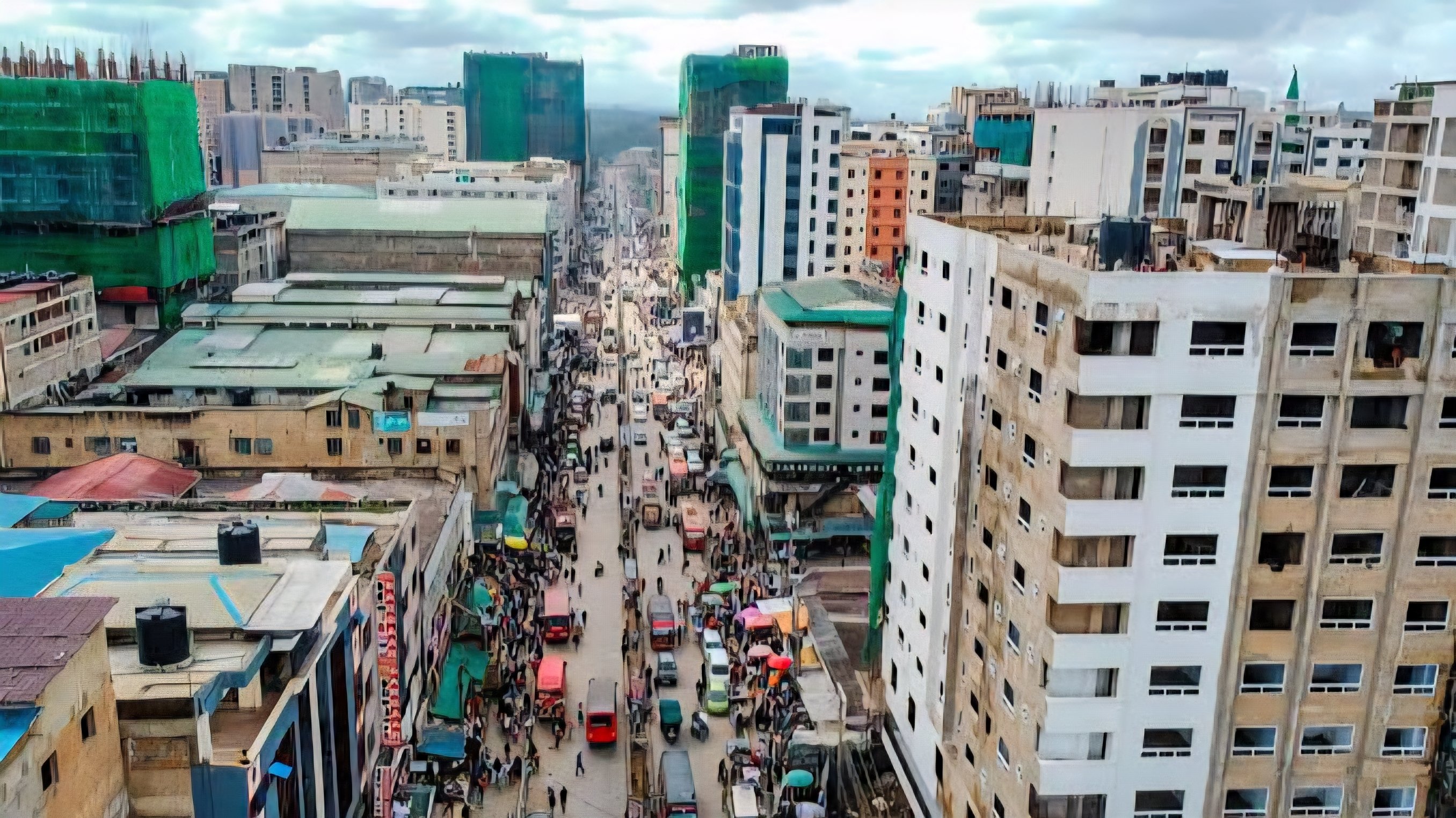 An aerial view of a densely populated street in Eastleigh, Nairobi, showing closely packed high-rise buildings and heavy traffic.
