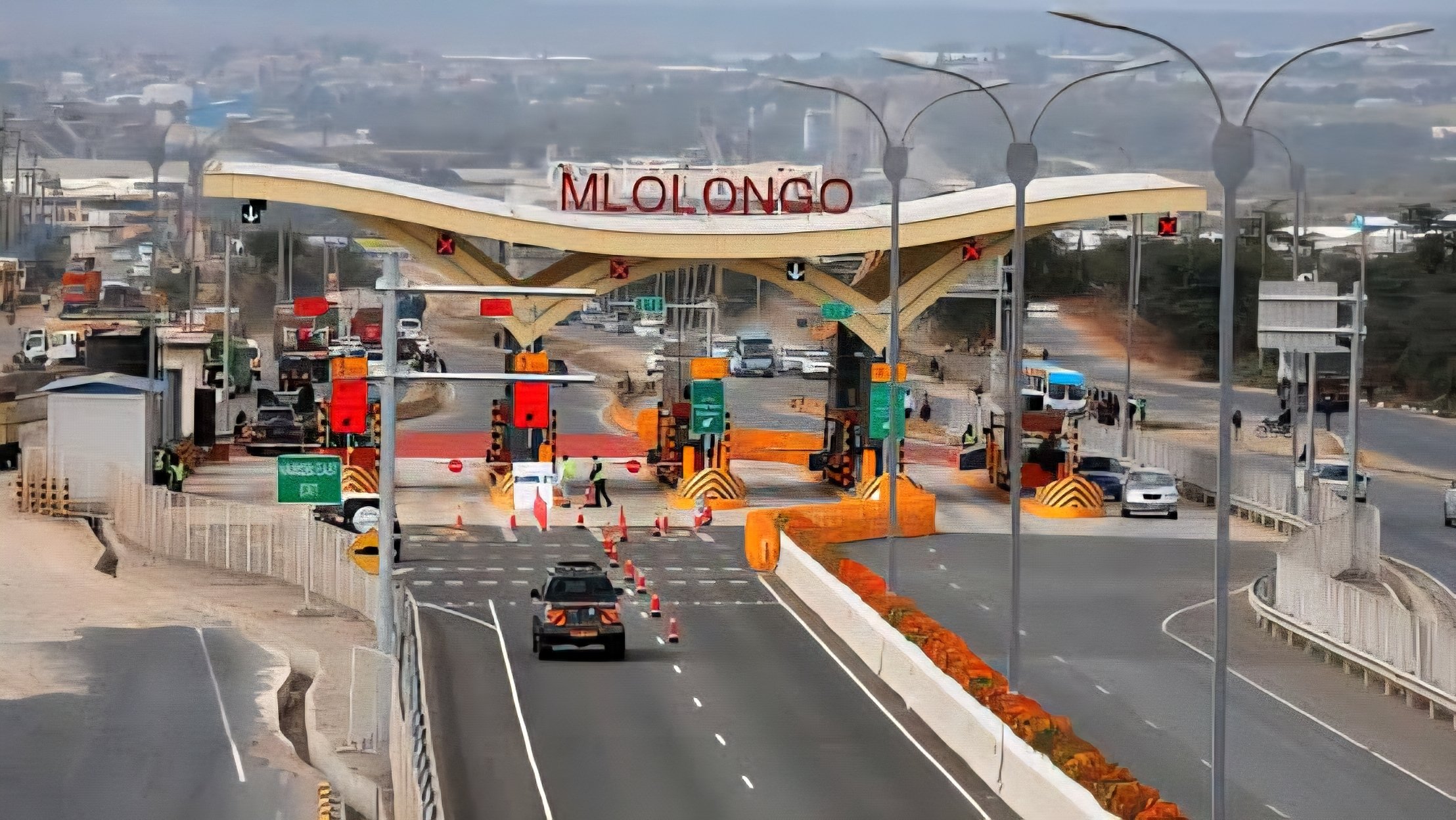 Vehicles navigating traffic on Mombasa Road near Mlolongo, with ongoing highway infrastructure visible in the background.