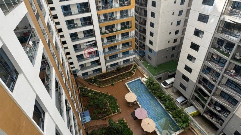 Aerial view of modern multi-story apartment buildings with a courtyard and swimming pool in a residential estate in Nairobi, Kenya.