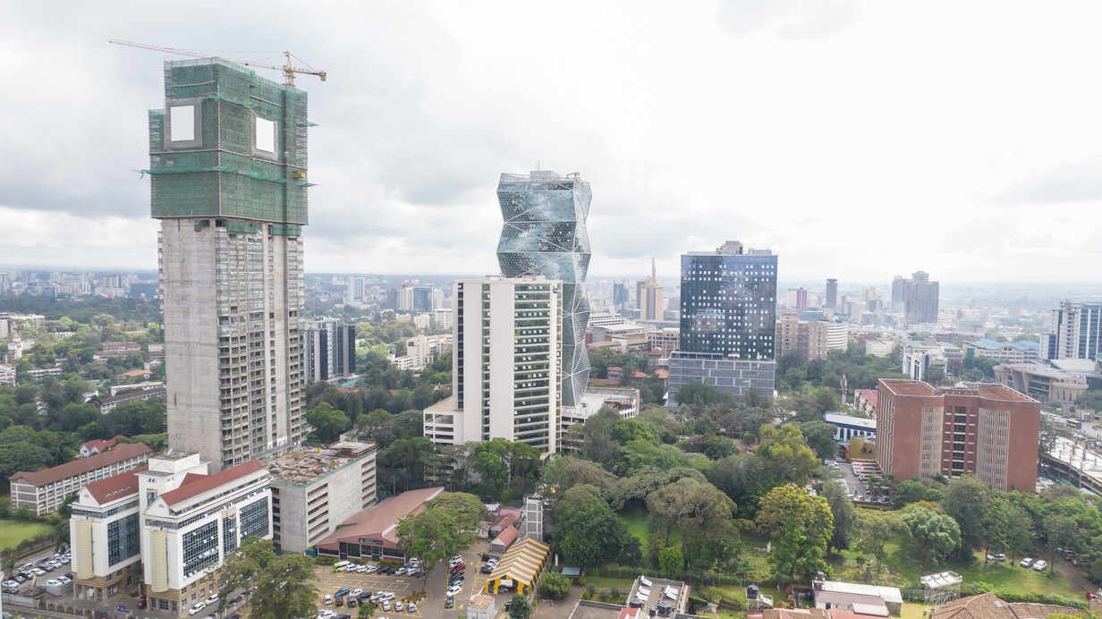 Aerial view of the Westlands skyline in Nairobi showing dense clusters of high-rise commercial and residential buildings under a hazy sky.