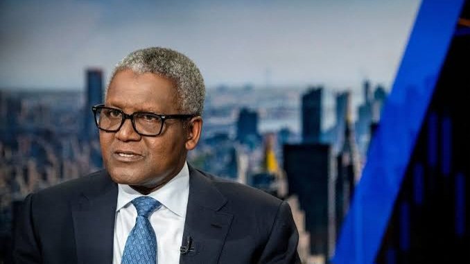 Close-up portrait of billionaire Aliko Dangote wearing glasses and a dark suit jacket.