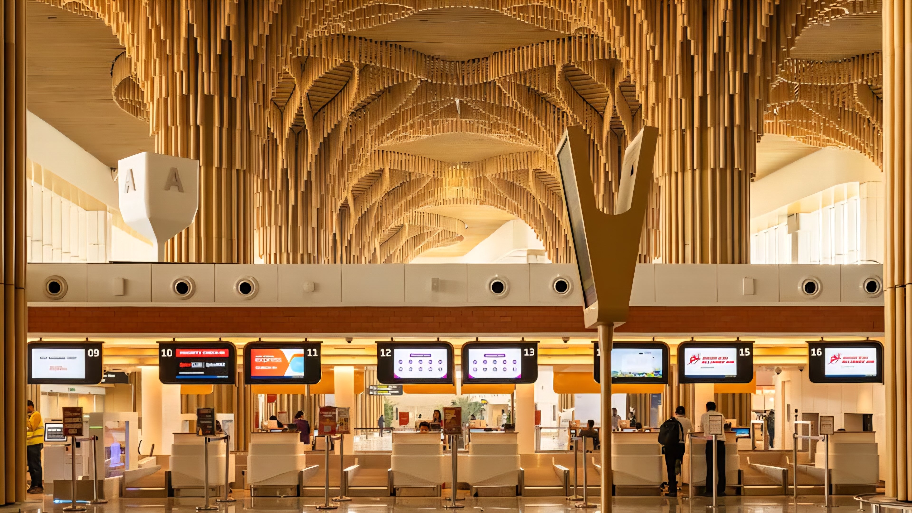 Interior view of an airport terminal featuring soaring wooden columns and an intricate vaulted ceiling structure.