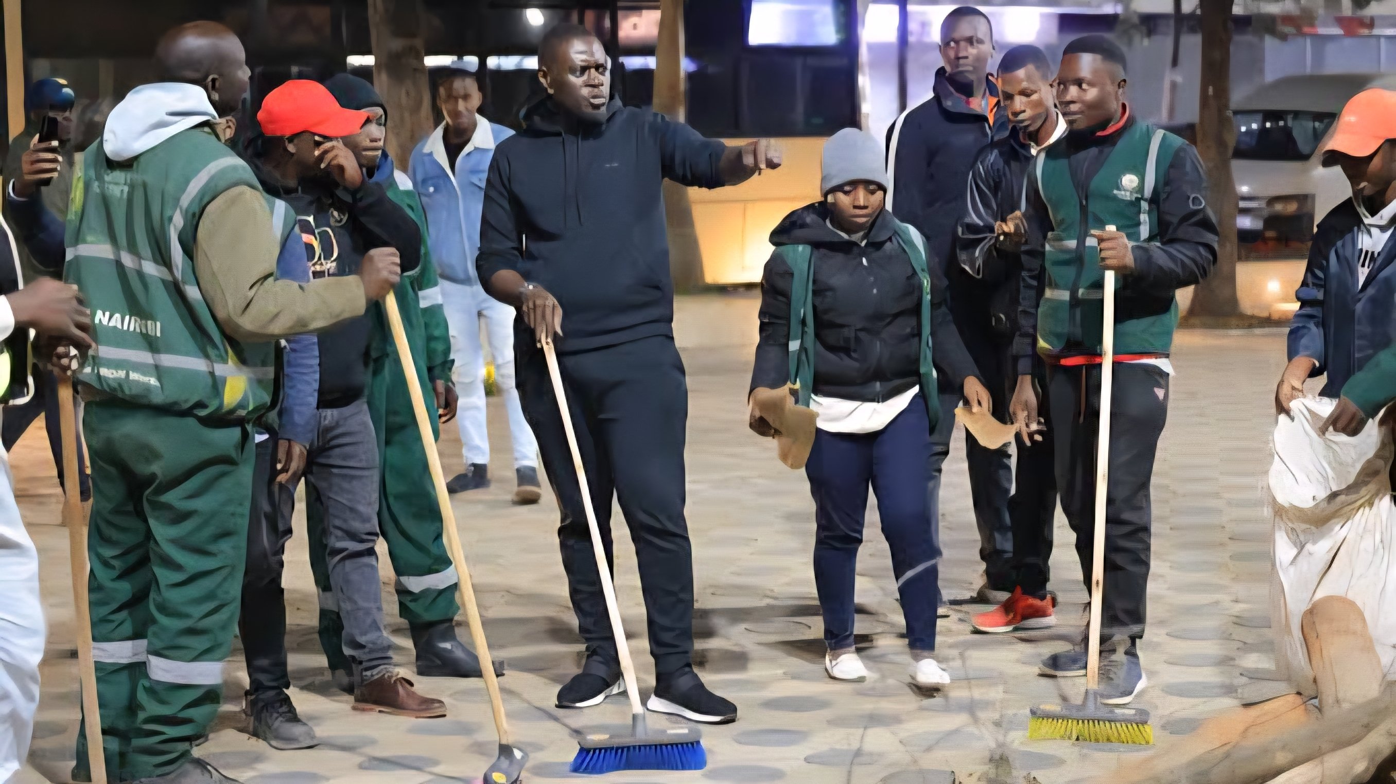 Four panels showing Governor Johnson Sakaja and county staff sweeping streets, loading waste bags into a truck, and a cleaned pedestrian walkway in Nairobi CBD at night.