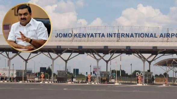 The main entrance gate of Jomo Kenyatta International Airport in Nairobi with the airport name visible on the signage above the vehicle lanes.