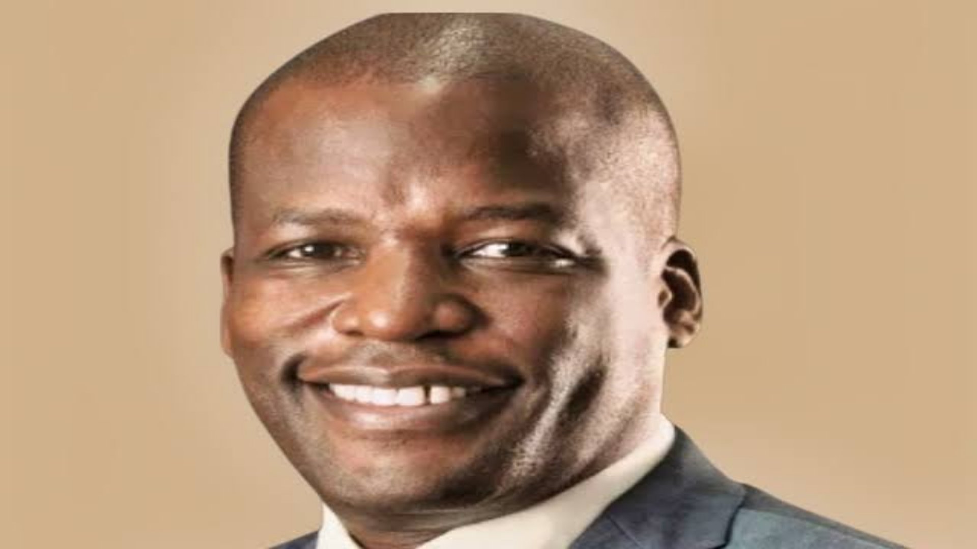 A professional portrait of Geoffrey Ndugwa, the CEO of Bamburi Cement Plc, dressed in a sharp business suit.