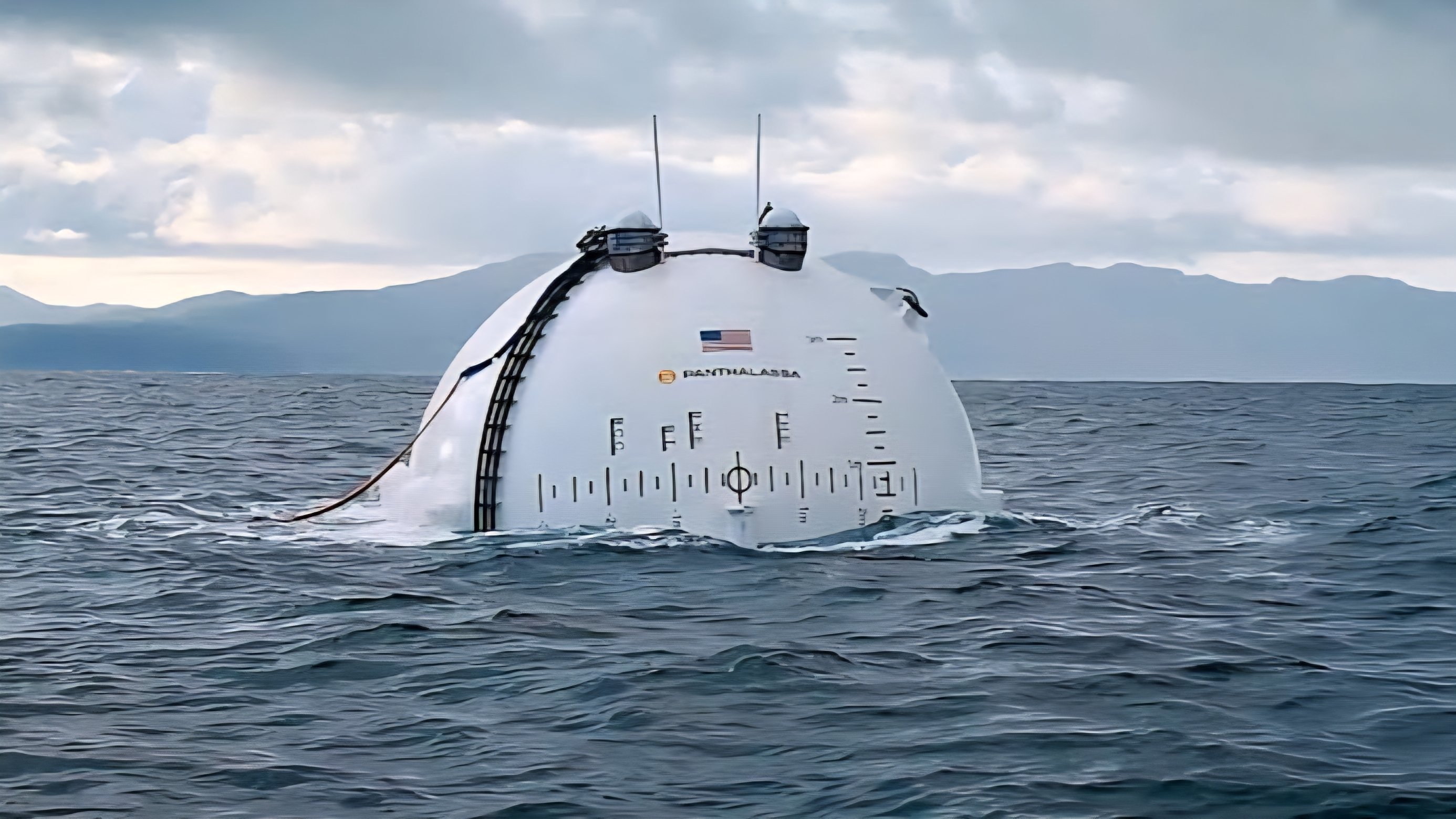 A white spherical and cylindrical marine energy structure floating in open sea waters.