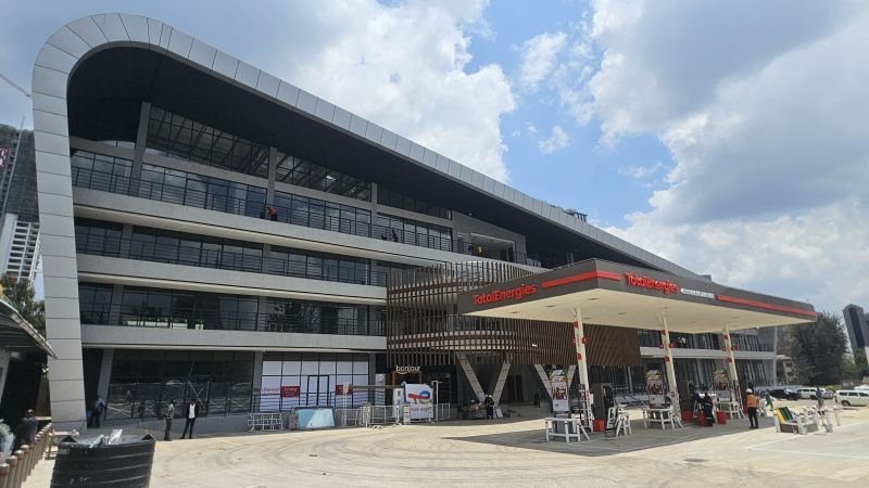 Aerial view of a modern shopping mall and office complex in Nairobi showing parking lots and nearby highway infrastructure.