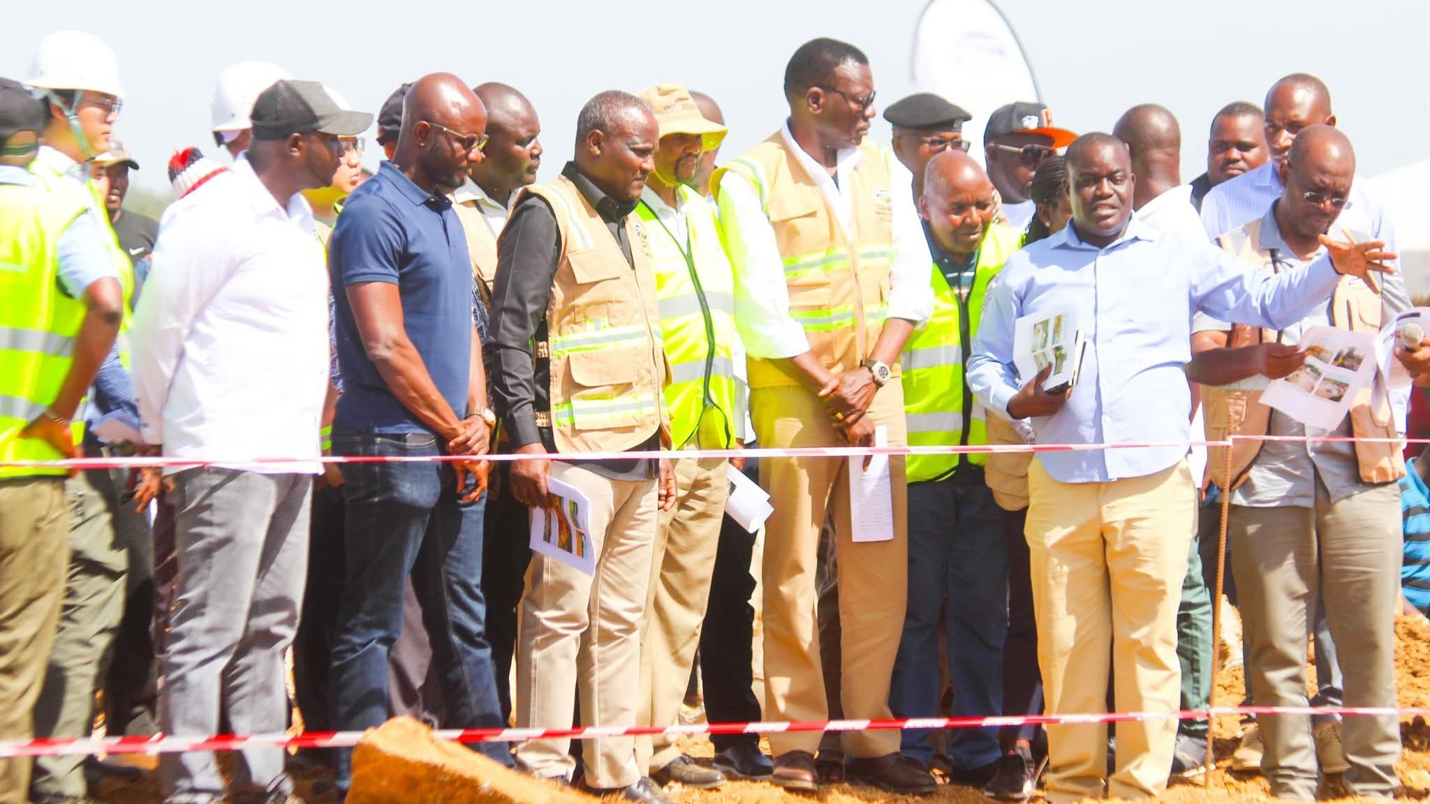 Cabinet Secretaries Davis Chirchir and John Mbadi walking across a construction site with engineers and local leaders at the Dhogoye Bridge project in Bondo