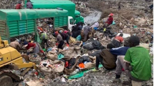Waste pickers working around a lorry at Dandora dumpsite amid piles of mixed waste