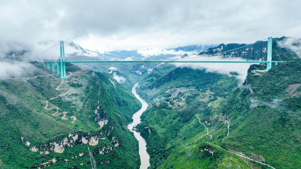 Huajiang Grand Canyon Bridge: Aerial view of the world's highest bridge, a steel truss suspension structure soaring 625 meters above the deep gorge in Guizhou, China.
