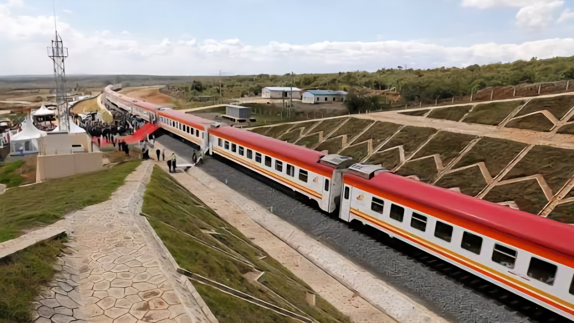 A Kenya Railways freight locomotive and cargo wagons positioned on the Standard Gauge Railway tracks at a terminal.