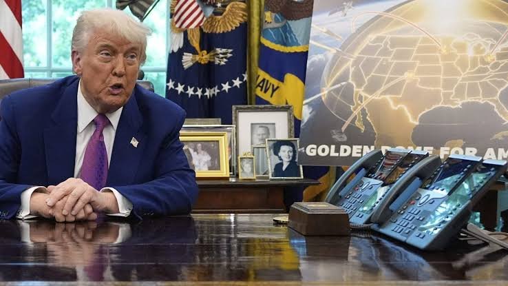 President Donald Trump gesturing while speaking at a desk in the Oval Office at the White House.