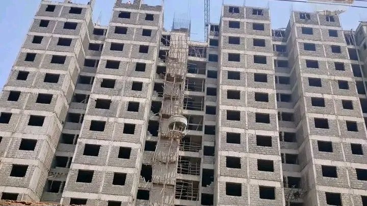 Multi-story residential apartment block under construction in Nairobi showing concrete block masonry and scaffolding