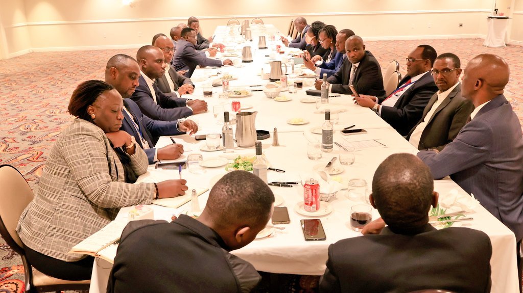 A group of high-level officials and financial representatives from Uganda and Citibank seated around a long conference table during a formal meeting in Washington, DC.