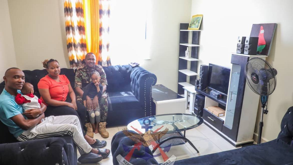 A KDF soldier in uniform and his family sitting in the living room of a modern, well-furnished apartment at Roysambu Military Camp.