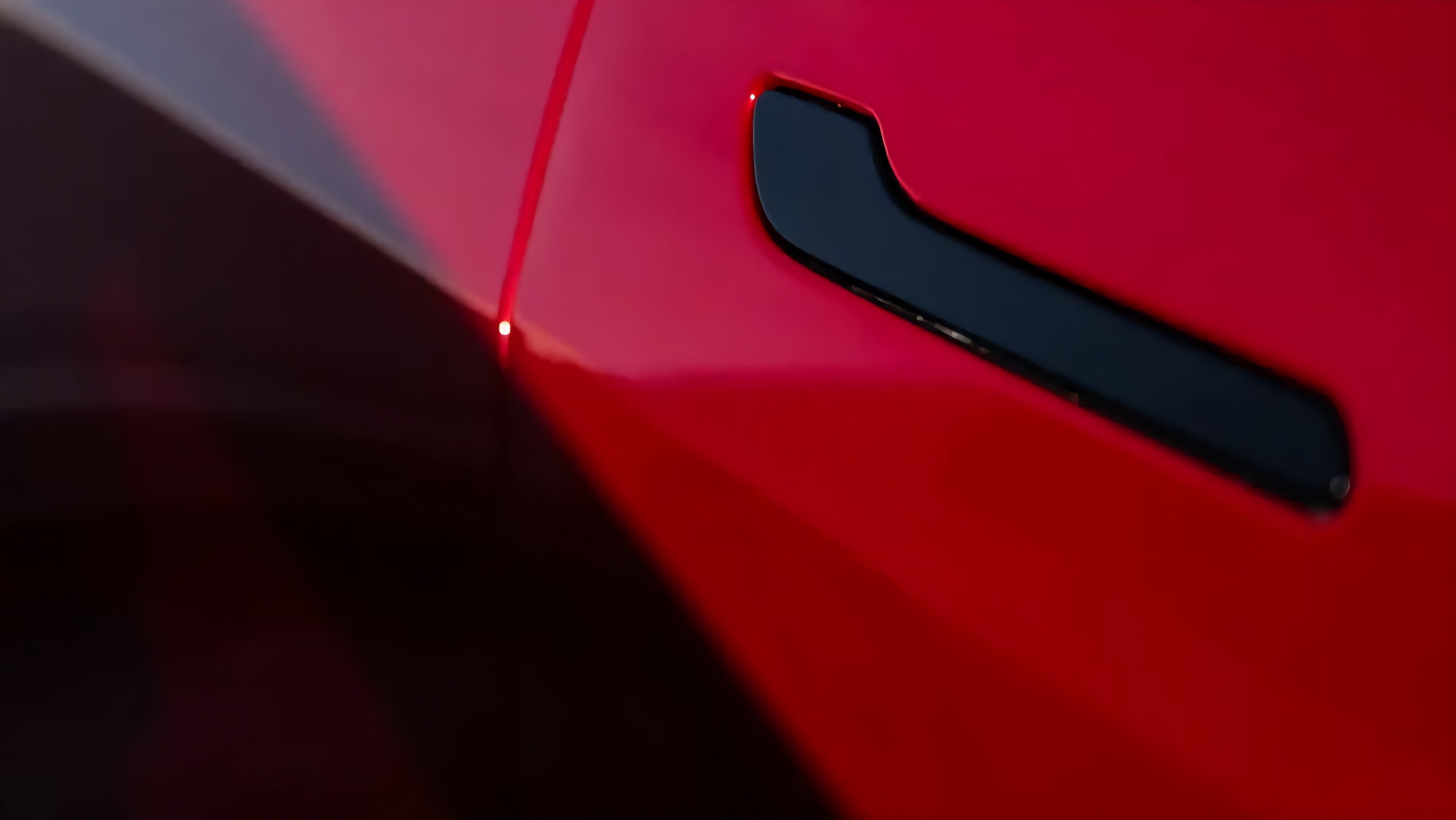 Close up of a red electric vehicle exterior door handle.