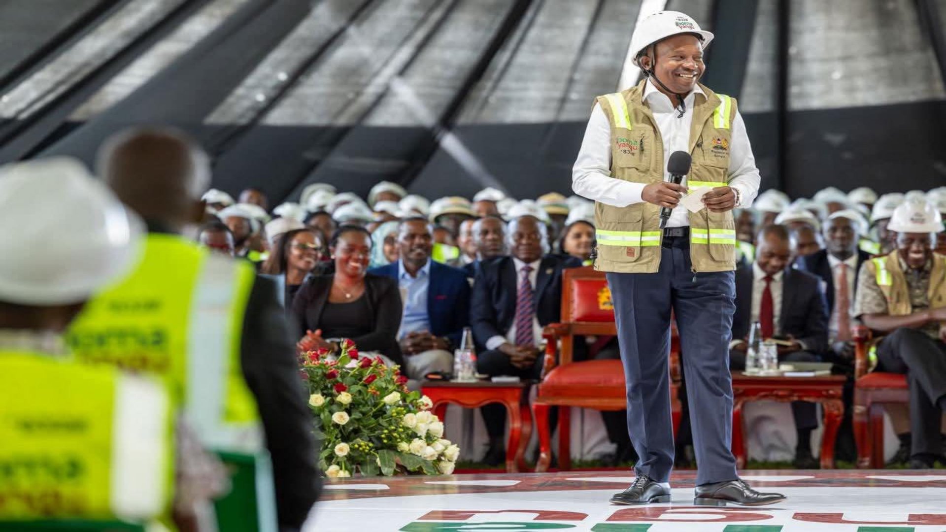 A professional gathering of government officials and construction industry stakeholders during a formal address in Kenya.