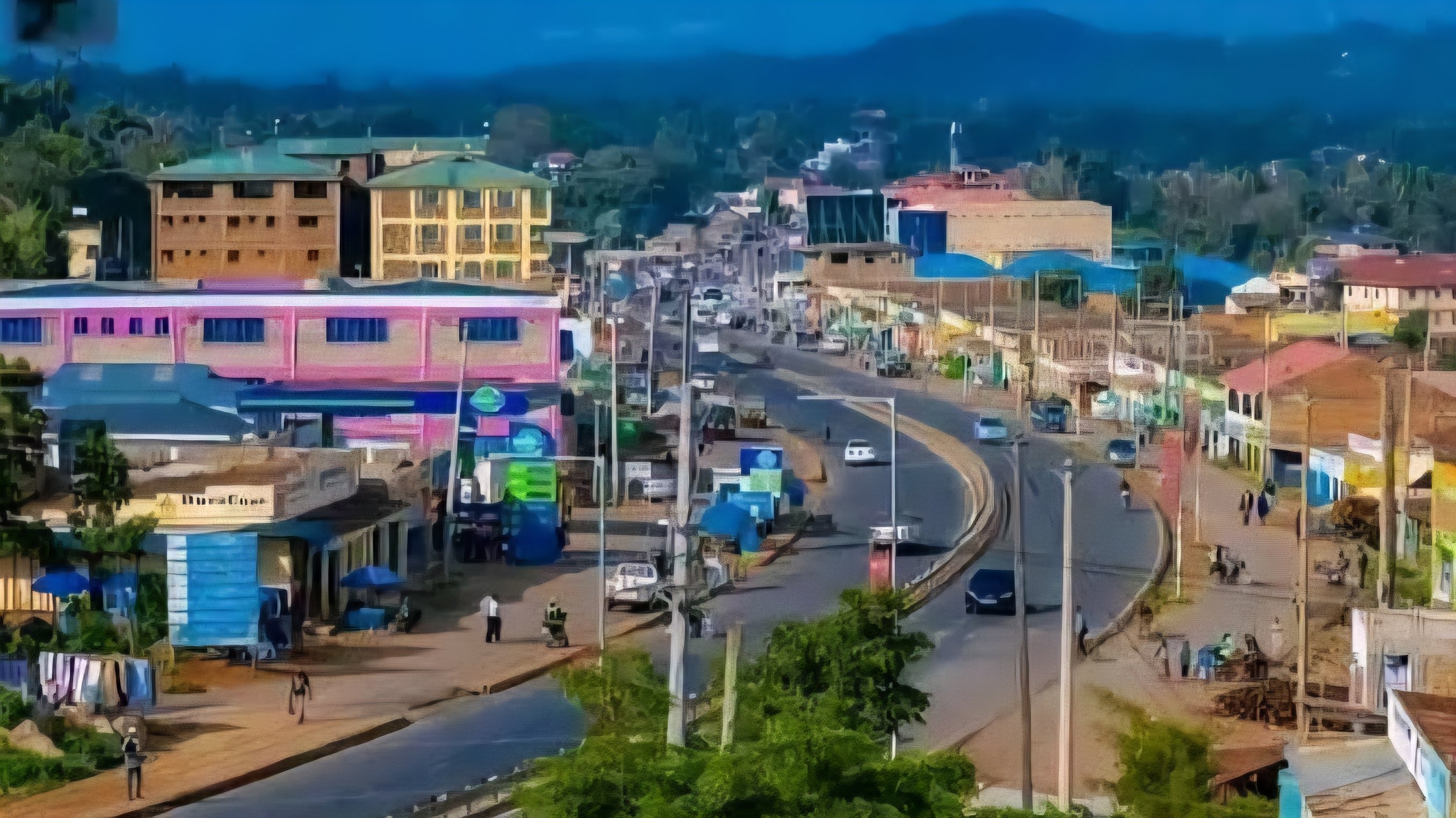Aerial view of a busy urban street in Oyugis Town featuring multi-story commercial buildings and heavy traffic along the Kisii-Kisumu highway.