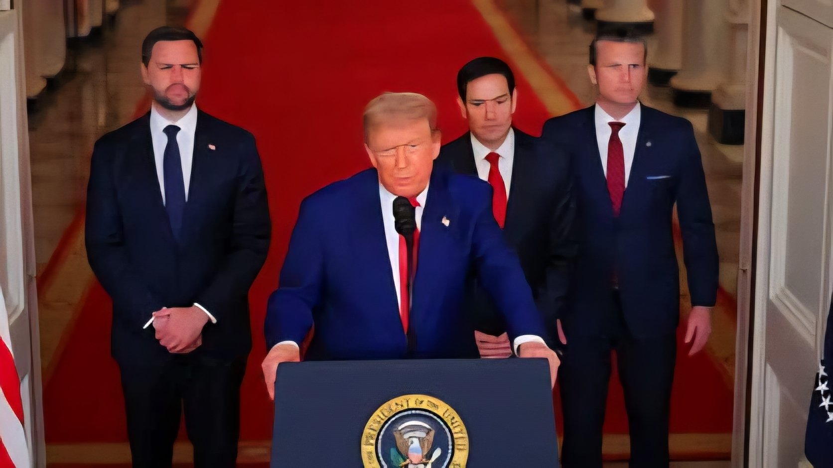 President Donald Trump stands at a podium in the White House flanked by officials including Marco Rubio and J.D. Vance during a press conference regarding trade policy and Supreme Court rulings.