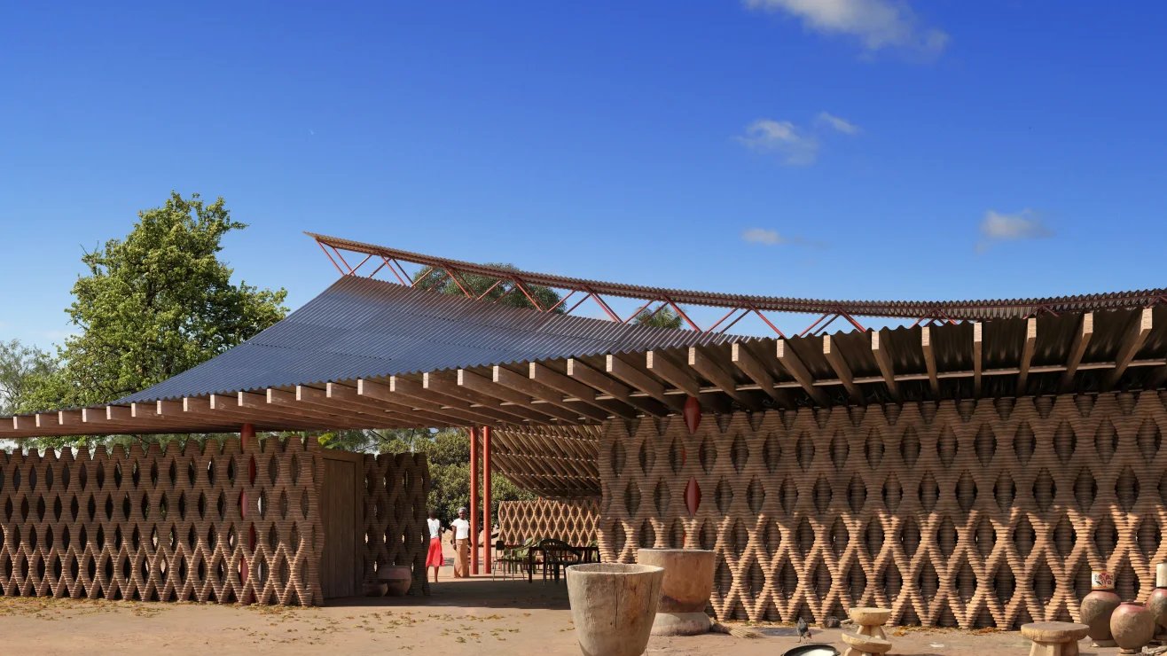 3D printer extruding earth-based material for house walls alongside example of traditional African earthen structure