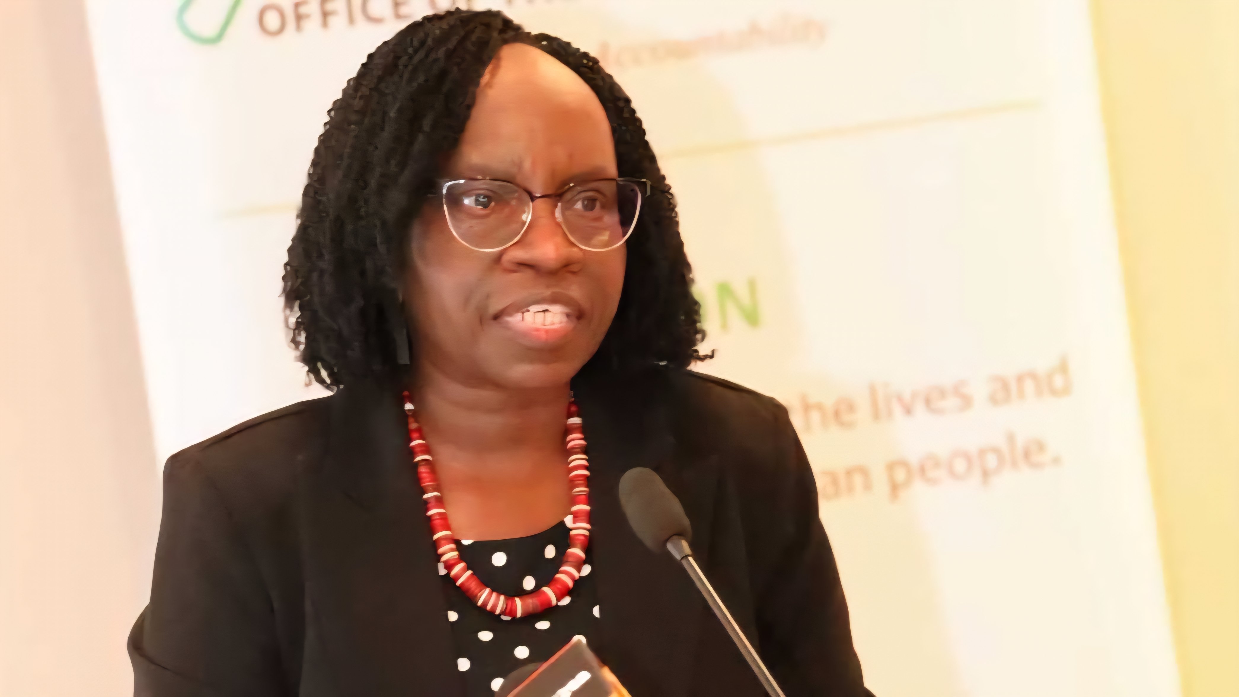 Close-up of a government official speaking into a microphone during a press briefing regarding a land audit.