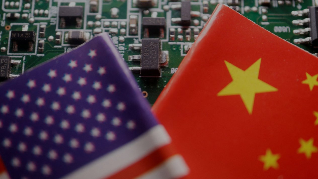 US and Chinese national flags displayed side by side over electronic circuit board components