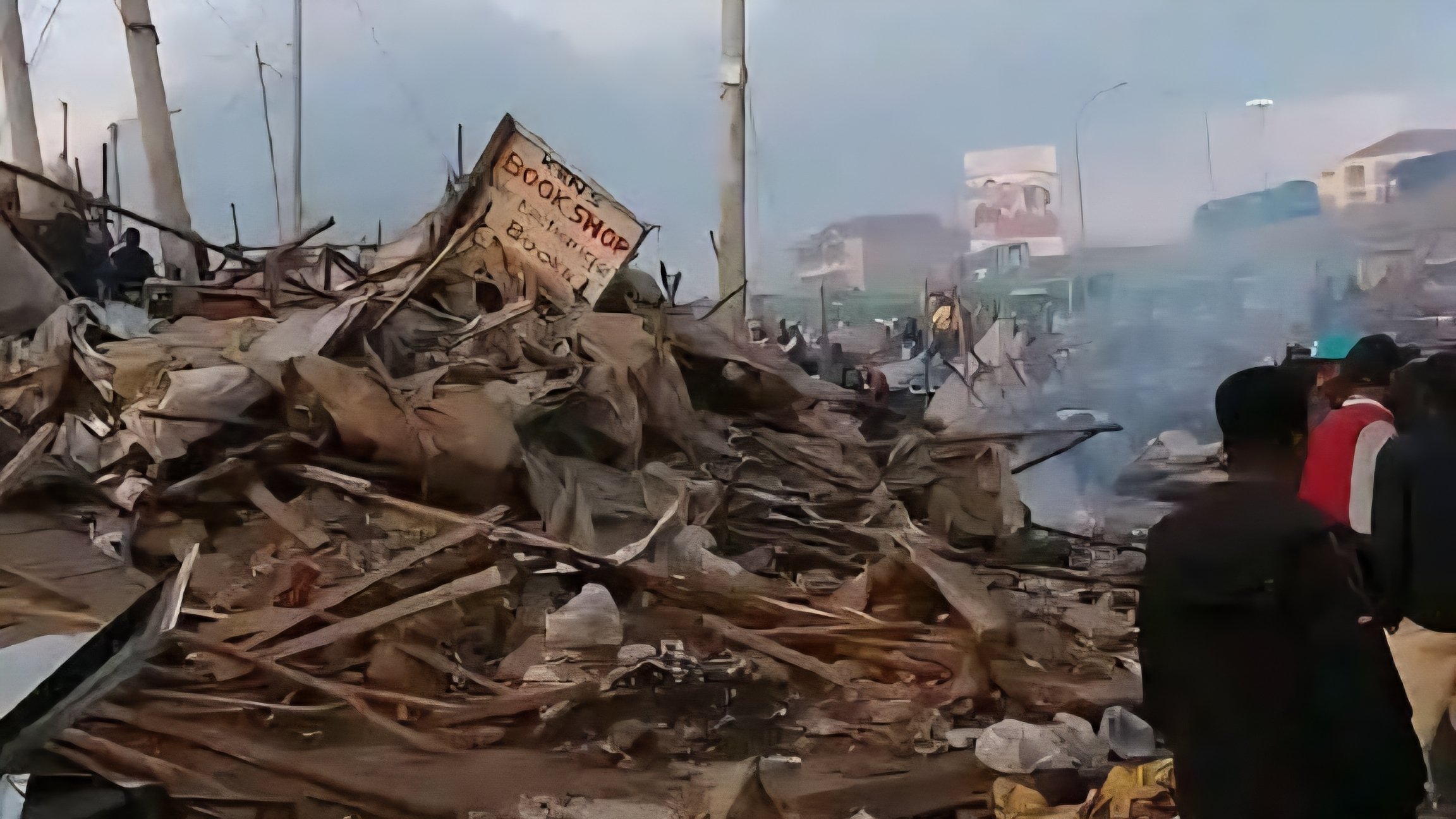 A wide shot showing the aftermath of demolitions at Githurai market with piles of debris, wooden planks, and twisted metal where stalls once stood.