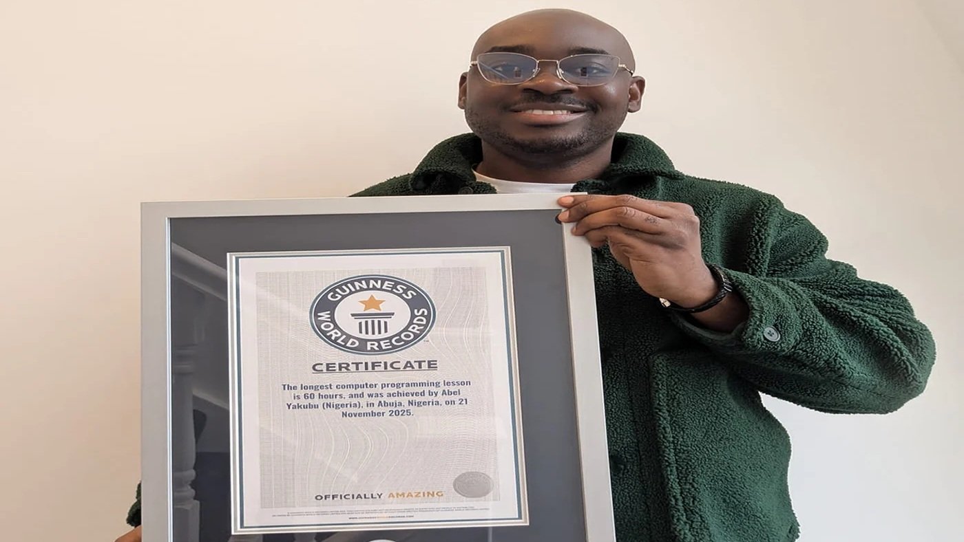 Cloud engineer Abel Yakubu stands with participants during his 60-hour Guinness World Record attempt for the longest computer programming lesson in Abuja.