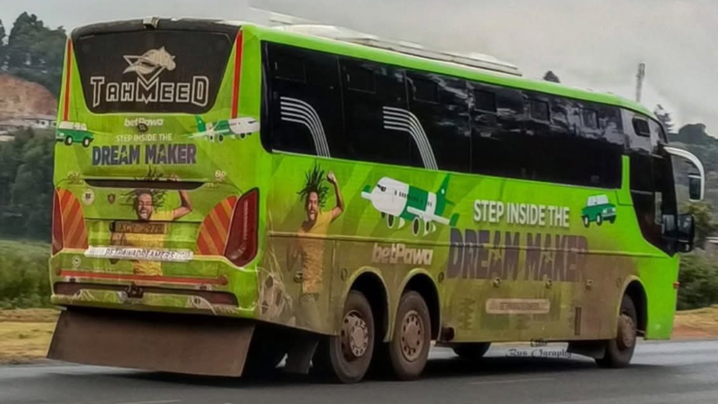A green Tahmeed long-distance bus wrapped in a full-body betPawa corporate advertisement traveling on a Kenyan highway, as seen in 257209.png and 257210.png.