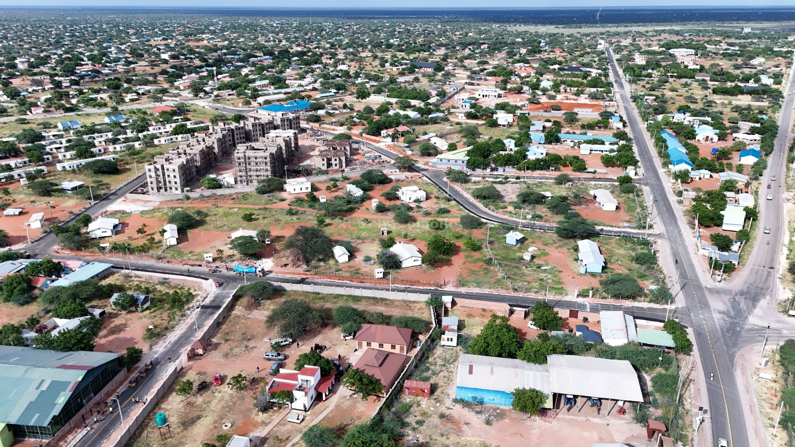 Aerial view showing newly paved bitumen roads with clear markings and solar street lighting installations in Wajir Town.