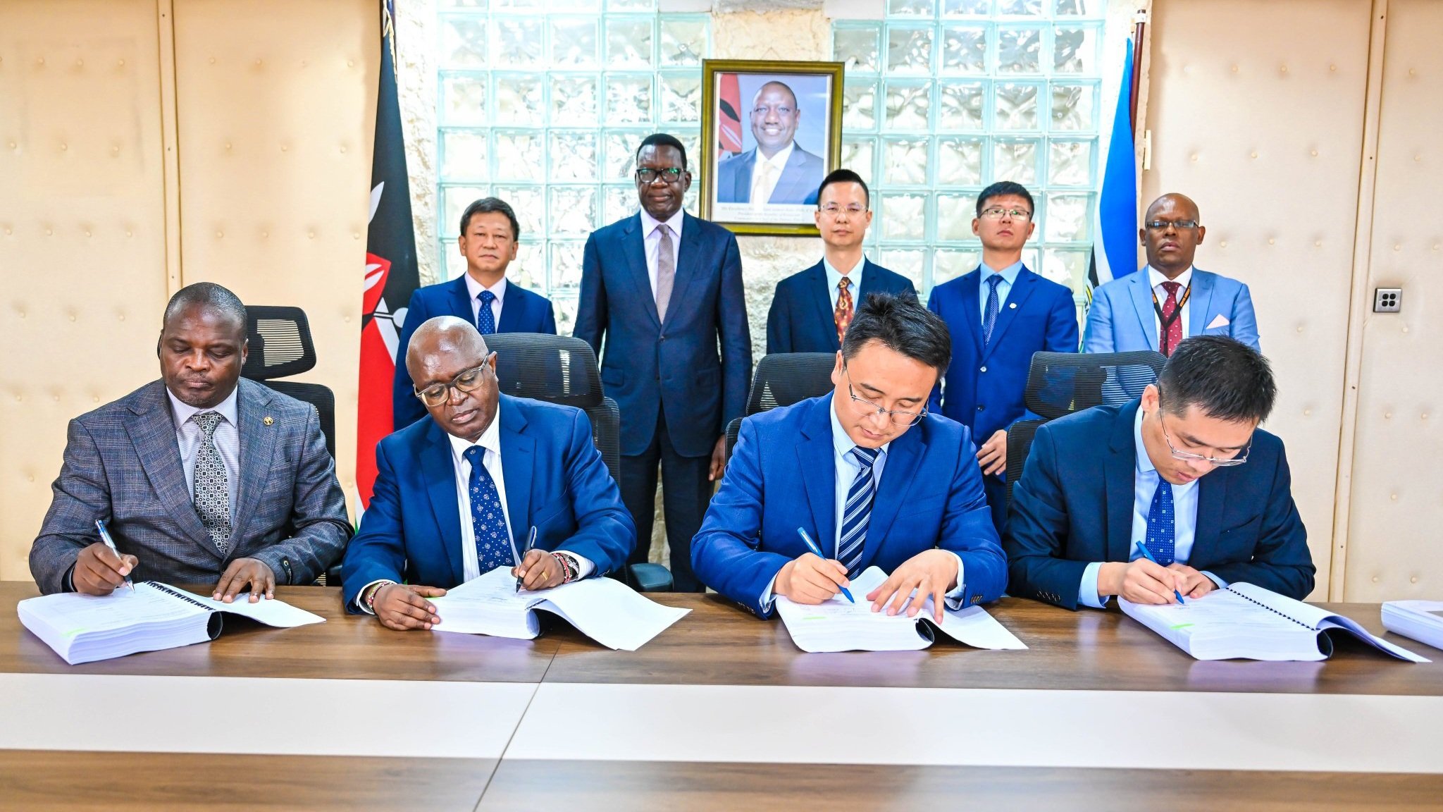 Cabinet Secretary Davis Chirchir and KURA officials seated at a conference table during the formal signing of the Kiambu Road expansion contract with representatives from Stecol Corporation.