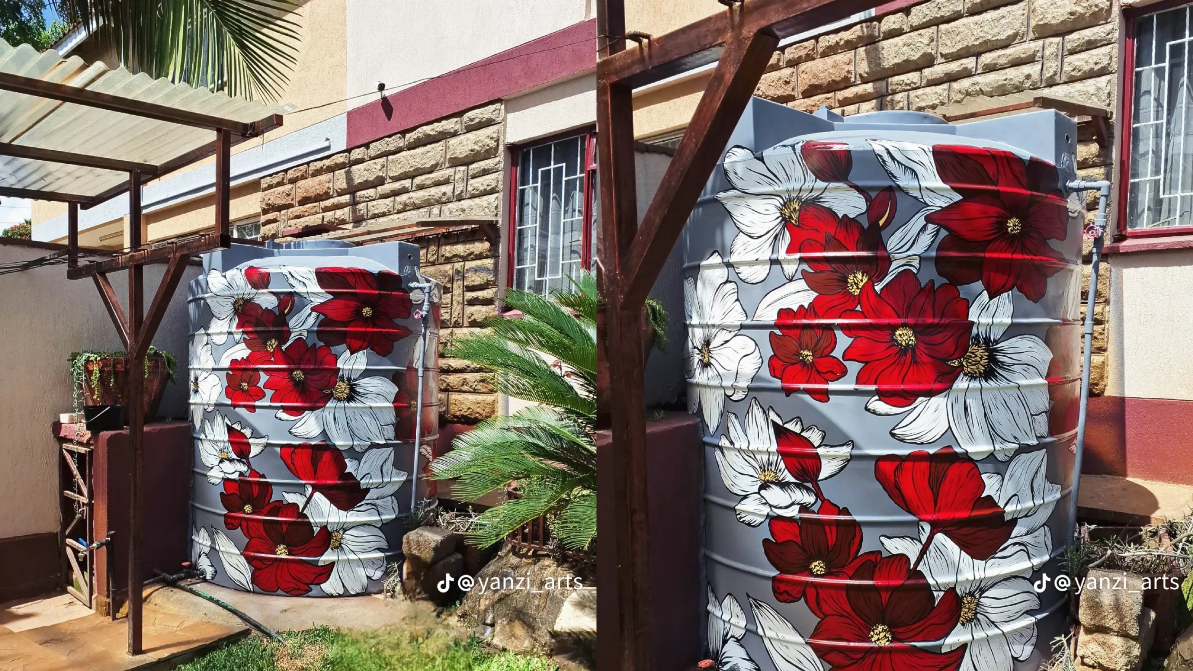 A large grey plastic water tank in a residential yard featuring a hand-painted mural of large red and white flowers.