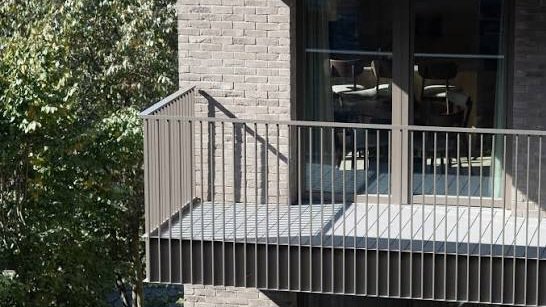 Modern residential apartment building featuring a steel balcony against a brick façade in Nairobi, Kenya.