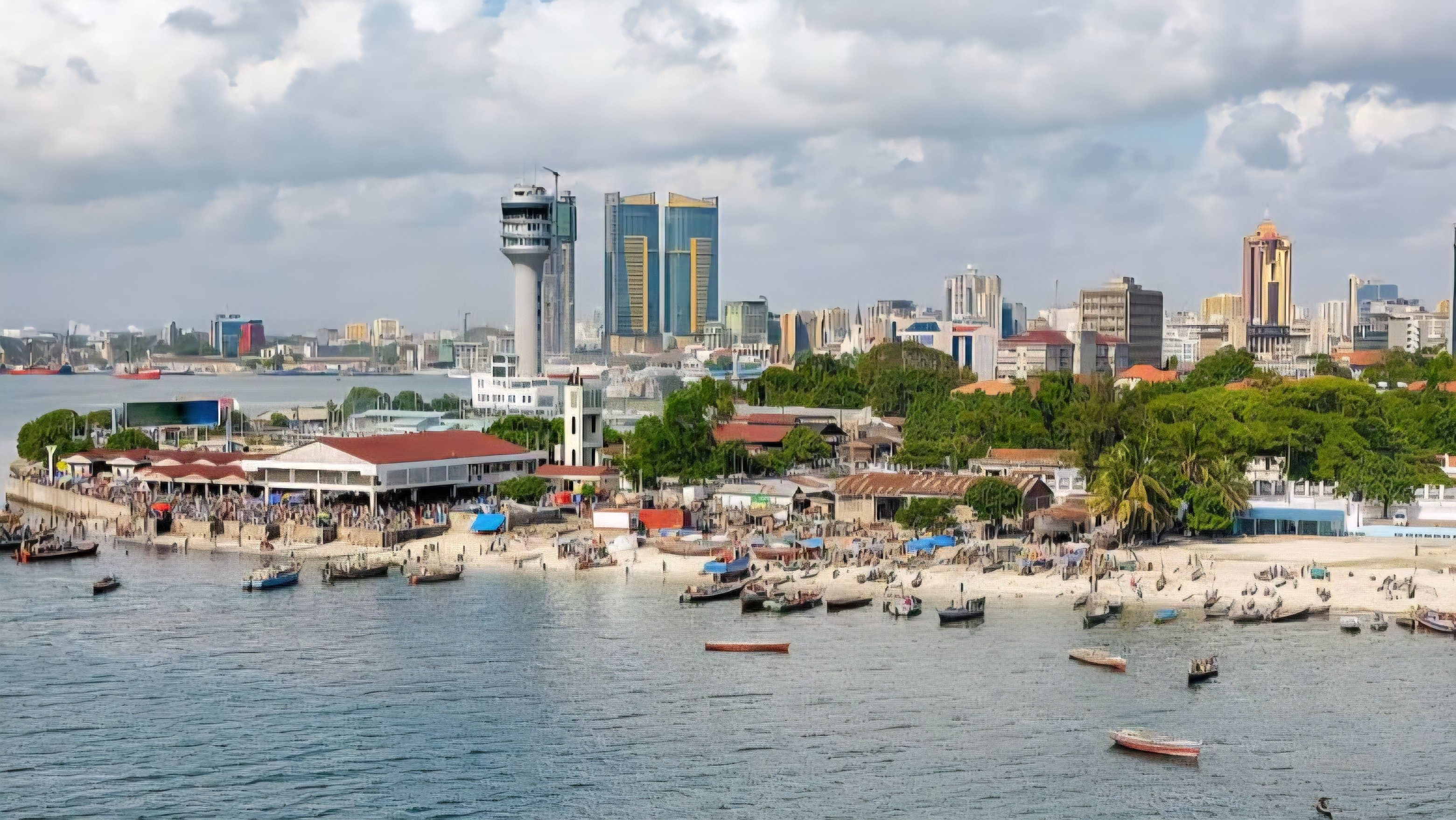 Aerial view of the Dar es Salaam skyline and waterfront showing modern high-rise buildings and the busy port area.
