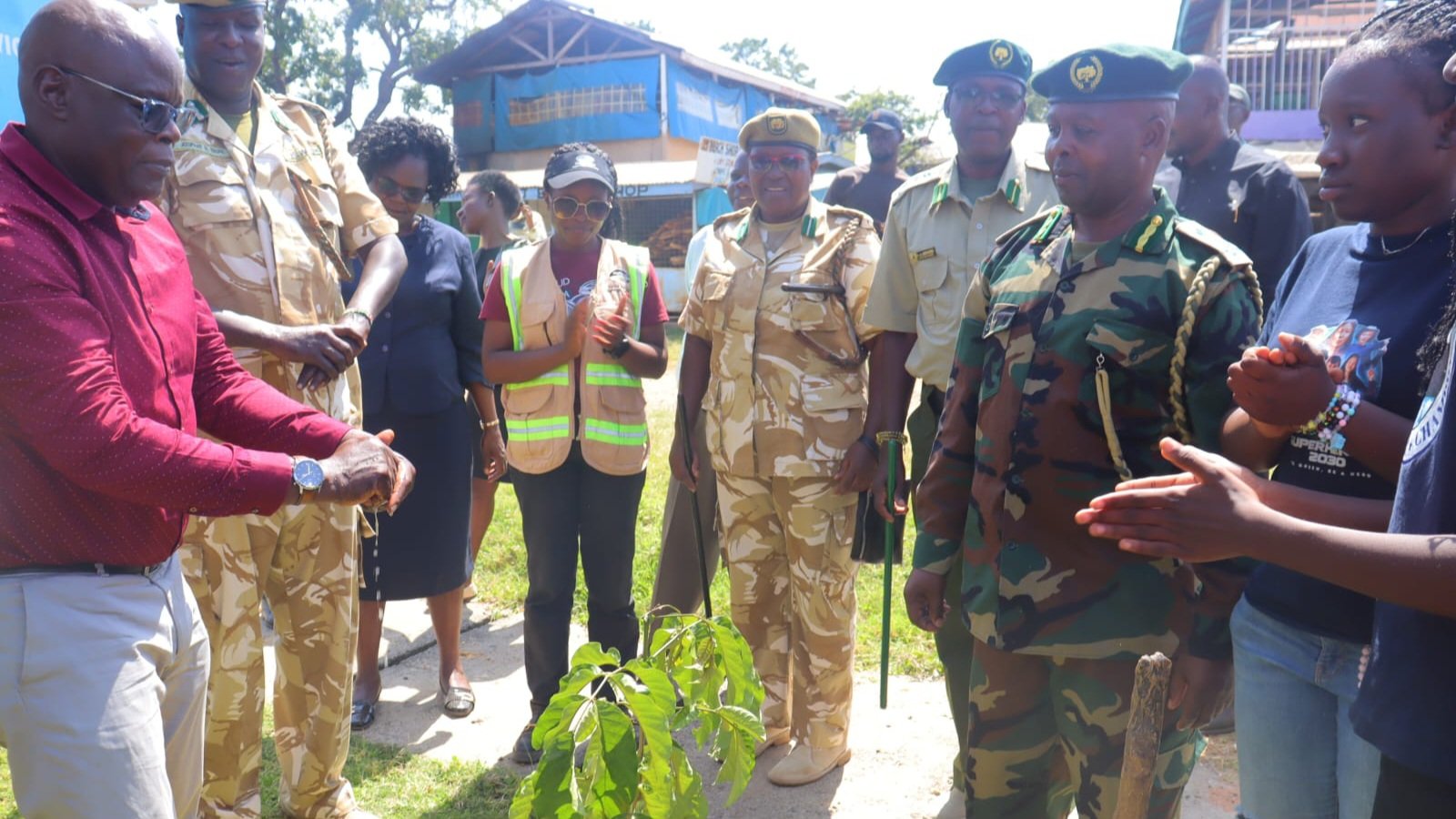 A group of people including KeNHA officials and local community members participating in a tree planting exercise at the Dunga Community Playground in Kisumu.