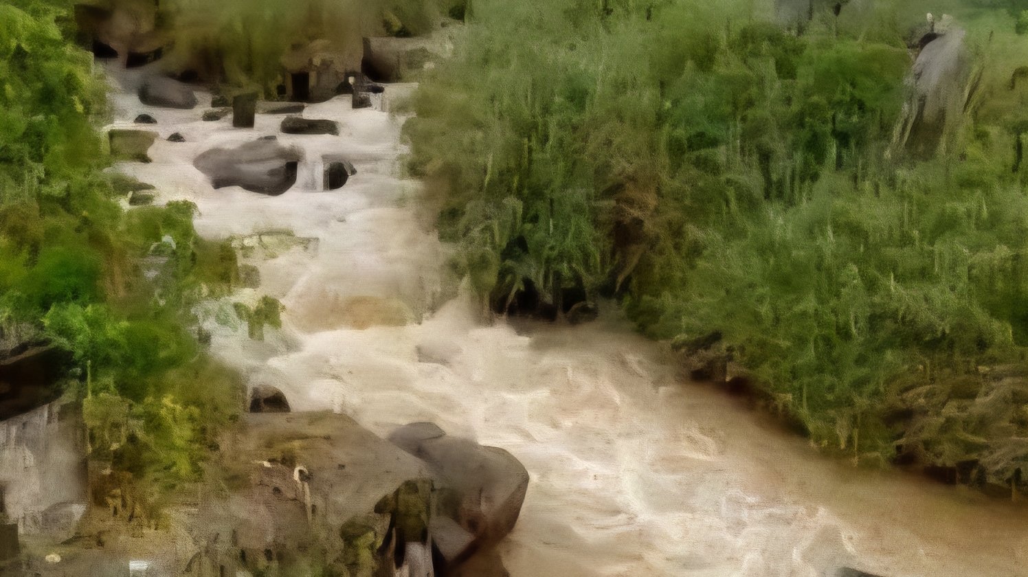 A scenic view of Ruiru River flowing through green vegetation with a concrete bridge structure visible in Kiambu County.