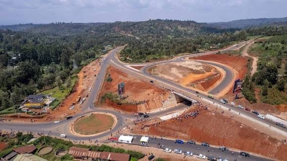 An aerial view of the newly constructed grade-separated Marua Interchange showing a modern highway layout with roundabouts and connecting lanes cut through a rural landscape.