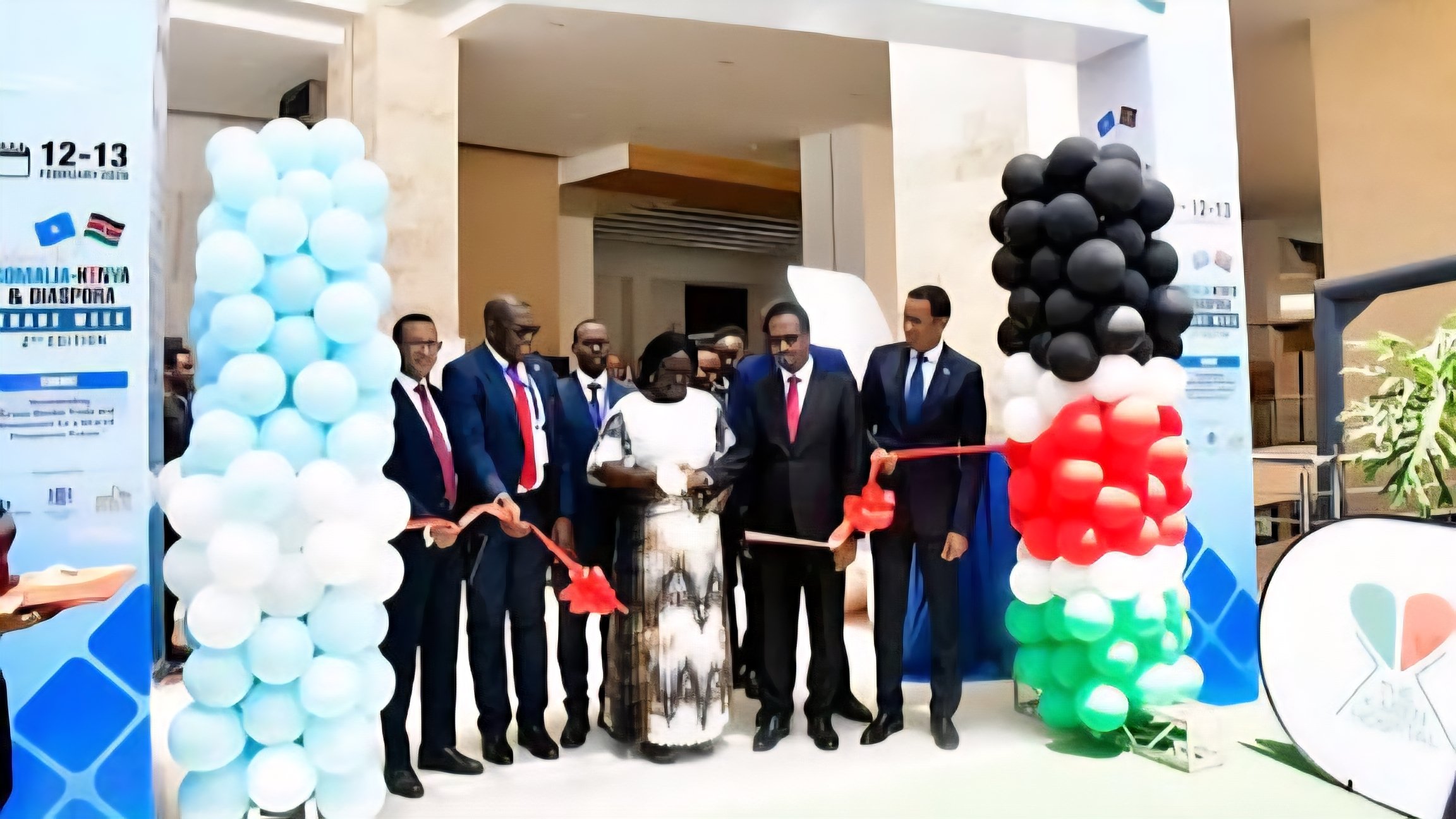 Government officials and trade representatives cutting a ribbon at the entrance of the Somalia-Kenya and Diaspora Trade Week event.