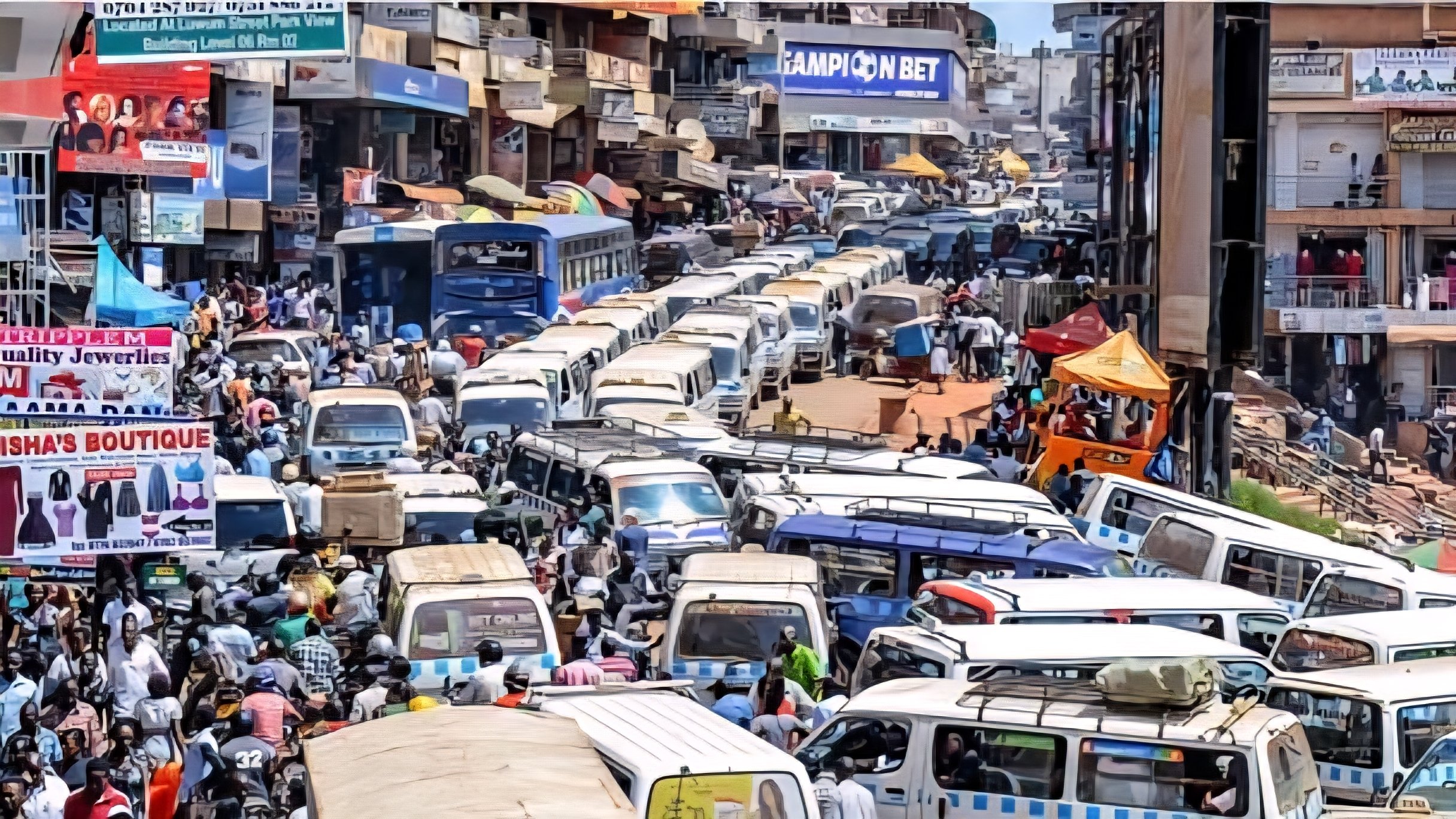 Dense traffic jam involving white commuter vans and cars on a crowded street in Kampala, Uganda.