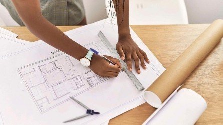 Illustration of a person reviewing building plans, representing unlicensed architects facing penalties under Kenya's Architects Bill 2026.