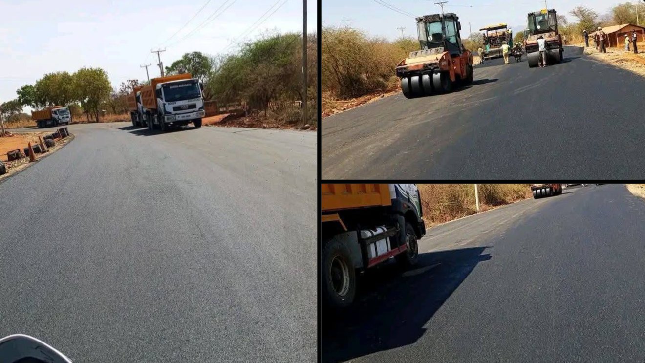 Heavy construction machinery and tipper trucks applying fresh asphalt along a road in Tharaka Nithi County.