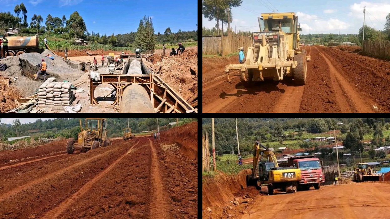 Heavy construction machinery performing earthworks and installing concrete drainage culverts on a rural dirt road.