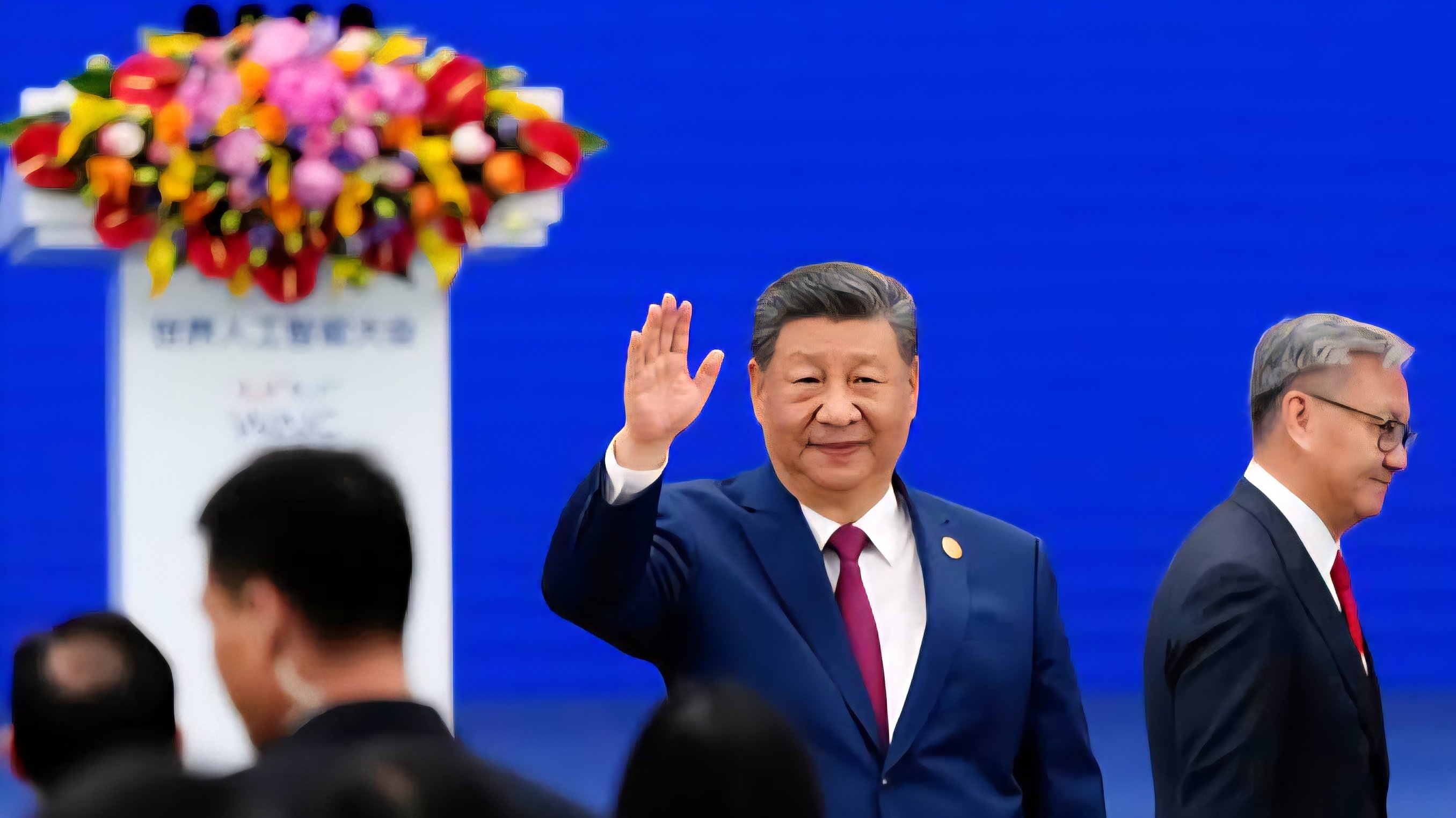 President Xi Jinping waves to an audience while standing on a stage at the 2026 World Artificial Intelligence Conference in Shanghai.